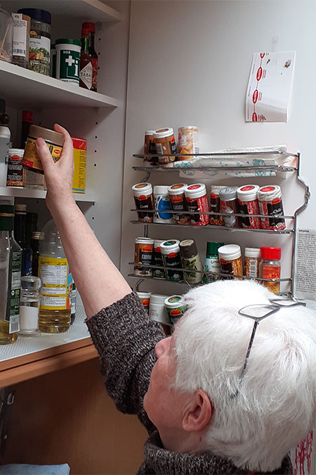 Bild Oberarmkopffraktur Patientin öffnetn den Küchenschrank